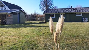 A rural setting with a green house, a wooden barn, and a clear sky. - 6 Person Holiday Home in Humble (Sydlangeland)
