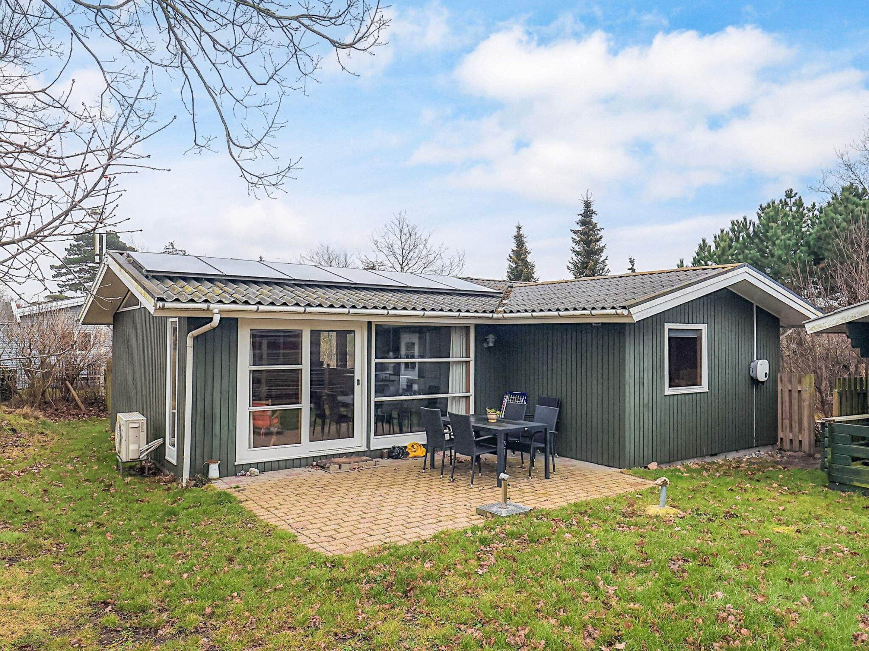 A single-story house with a patio area, a sliding glass door, and a small deck.