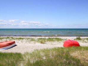 A beach with two boats, one red and one white, and a clear blue sky. - 4 Person Holiday Home in Store Fuglede (Store Fuglede)