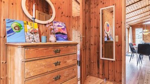 A wooden room with a dresser, a mirror, and artwork. - 4 Person Holiday Home in Store Fuglede (Store Fuglede)