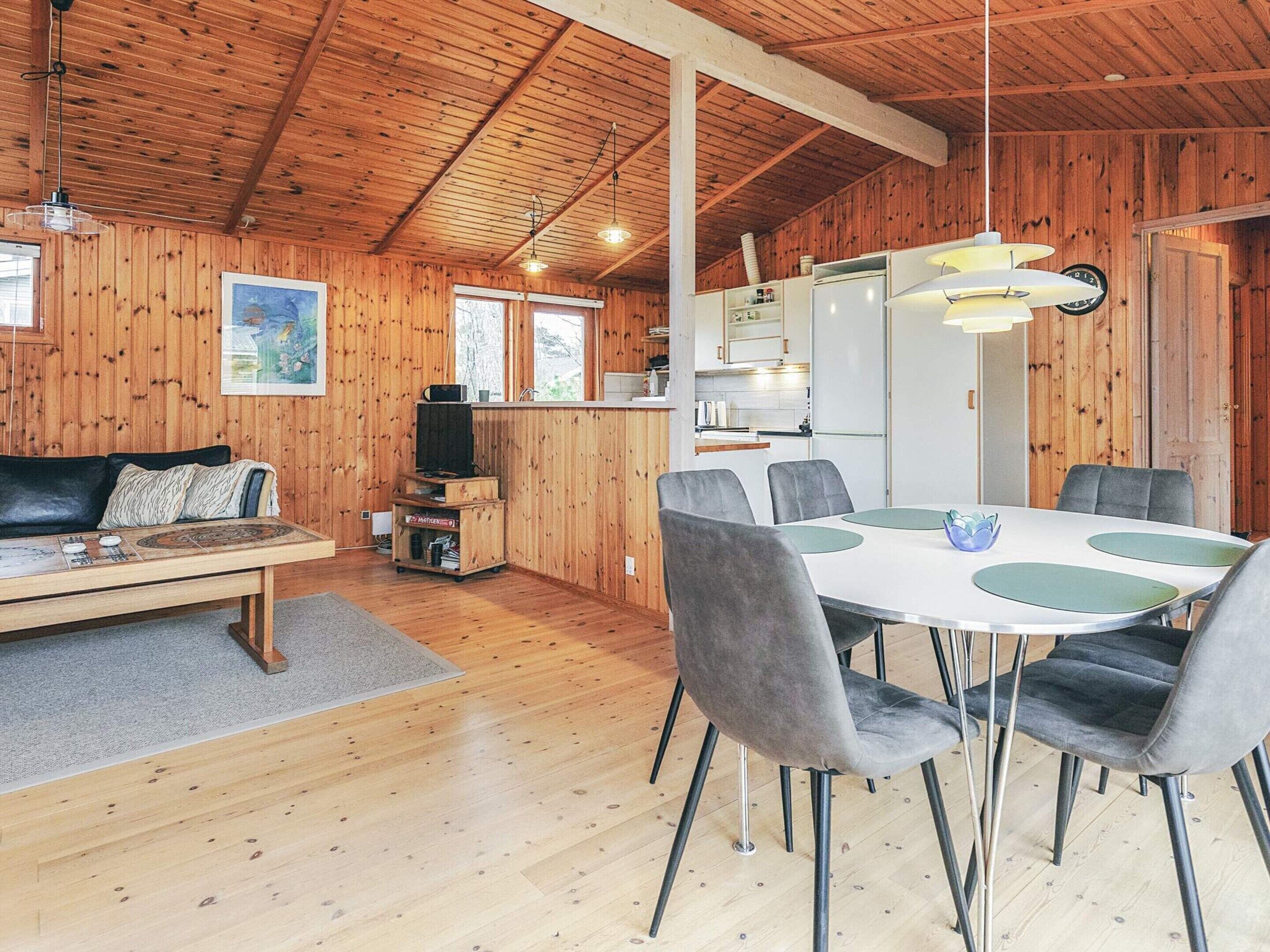 A cozy cabin interior with a dining area, kitchen, and living space.