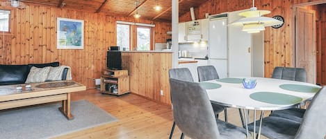 A cozy cabin interior with a dining area, kitchen, and living space.