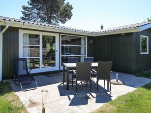 A patio with a table and chairs, a covered seating area, and a view of the surrounding landscape. - 4 Person Holiday Home in Store Fuglede (Store Fuglede)
