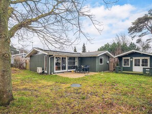 A single-story house with a patio area, a small deck, and a garage. - 4 Person Holiday Home in Store Fuglede (Store Fuglede)