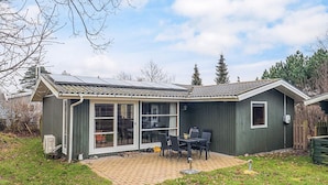 A single-story house with a patio area, a sliding glass door, and a small deck. - 4 Person Holiday Home in Store Fuglede (Store Fuglede)