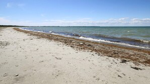 A beach with a sandy shore and a calm sea. - 4 Person Holiday Home in Store Fuglede (Store Fuglede)