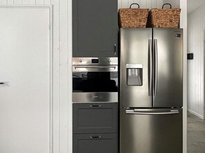 A stainless steel refrigerator with a water dispenser, a microwave, and two drawers below it. - 5 Star Holiday Home in Hacksvik (Håcksvik)