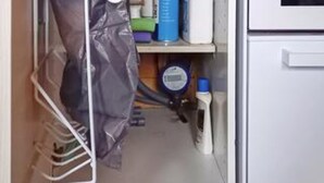 A storage area with a plastic bag hanging on a rack, a blue container, and a white cabinet. - 4 Person Holiday Home in Romo (Rømø)
