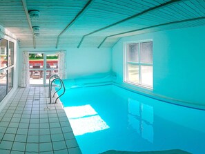 A swimming pool with a tiled floor and a metal ladder. - 5 Star Holiday Home in Nordborg (Nordborg)