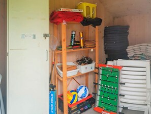 A storage area with shelves holding various items including sports equipment, a soccer ball, and a green foosball table. - 5 Star Holiday Home in Nordborg (Nordborg)