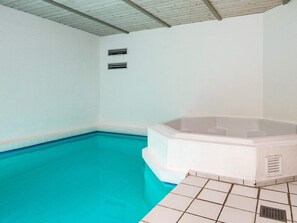 A swimming pool with a hot tub, tiled floor, and a ceiling with wooden beams. - 5 Star Holiday Home in Nordborg (Nordborg)
