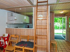 A wooden interior with a kitchen, a wooden ladder, and a view of greenery outside. - 5 Star Holiday Home in Nordborg (Nordborg)