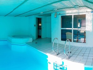 A swimming pool with a hot tub, a window with a view, and a door leading to a room. - 5 Star Holiday Home in Nordborg (Nordborg)