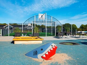 A playground with a shark-shaped play area, benches, and a basketball hoop. - 5 Star Holiday Home in Sydals (Sydals)