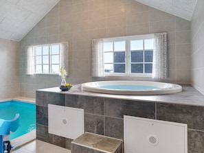A modern bathroom with a built-in hot tub, a window with curtains, and a shower area. - 5 Star Holiday Home in Sydals (Sydals)