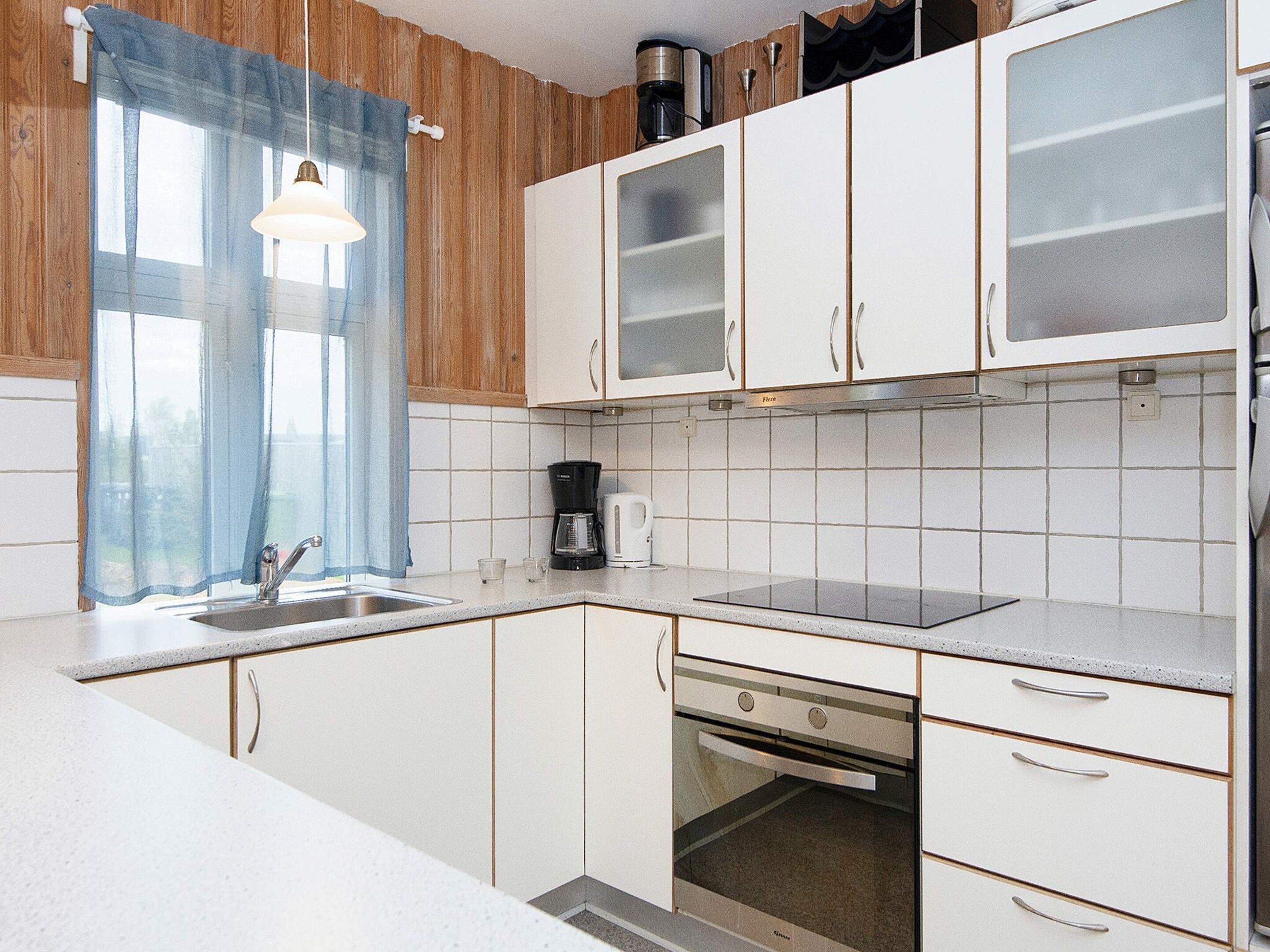A kitchen with white cabinets, a coffee maker, and a toaster.