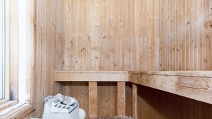 Un sauna avec des murs en bois et un banc.