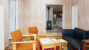 Ein Zimmer mit Kamin, Holzmöbeln und einem schwarzen Ledersofa.