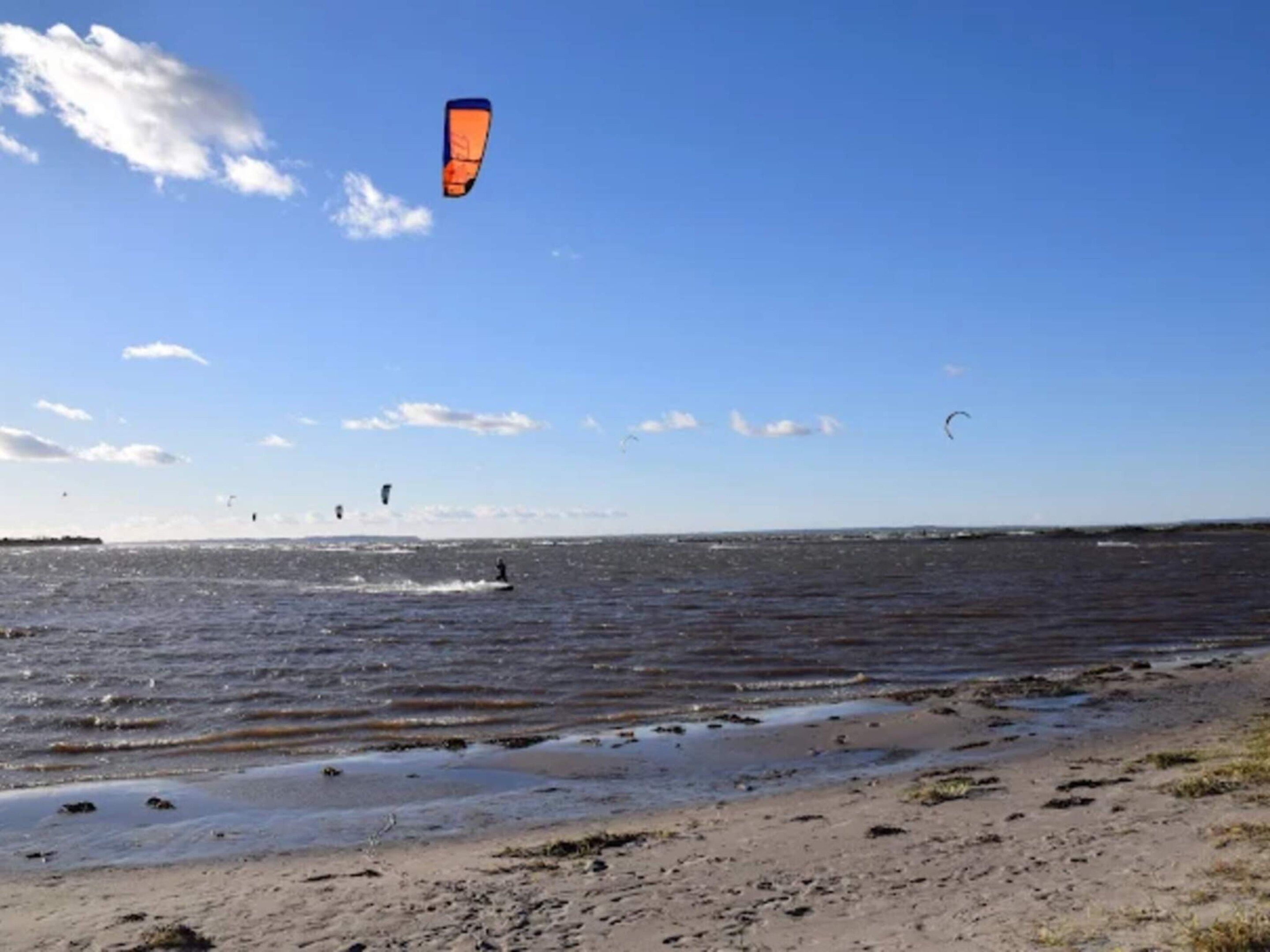 A beach with a clear sky and a body of water.