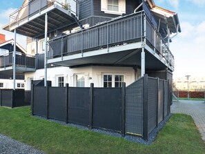 Ein mehrstöckiges Wohngebäude mit einem Balkon im oberen Geschoss.
