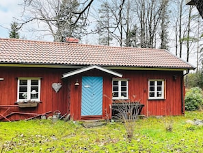 A red wooden house with a blue door, white windows, and a tiled roof. - 3 Person Holiday Home in Uddevalla (Uddevalla)