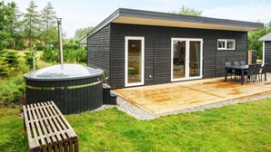 Une maison moderne dotée d’une terrasse, d’un jacuzzi et d’une table de patio.
