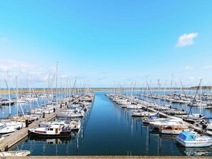 A marina with multiple boats docked along a wooden pier. - 5 Star Holiday Home in Wendtorf (Wendtorf)