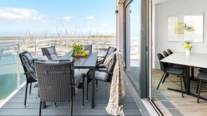 A balcony with a table and chairs overlooking a marina. - 5 Star Holiday Home in Wendtorf (Wendtorf)