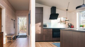 A modern kitchen with wooden cabinetry, a built-in oven, and a large window. - 4 Star Holiday Home in Ans By (Ans)