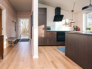 Una cocina moderna con armarios de madera, horno empotrado y un ventanal grande.