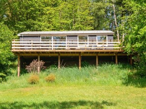 Eine hölzerne Plattform mit einem Balkon, umgeben von üppigem Grün.