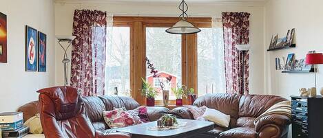 A living room with leather sofas, a coffee table, and a bookshelf.