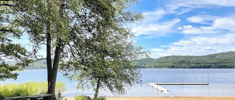 Un espace de pique-nique aménagé au bord du lac, avec un banc et une jetée qui s’avance dans l’eau.