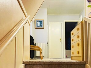 A staircase leading to a room with a radiator, a door, and a wooden dresser. - 6 Person Holiday Home in Amal (Åmål)