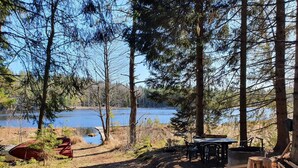 A campsite with a table and chairs, a red canoe, and a wooden bench. - 5 Star Holiday Home in Asbro (Asbro)