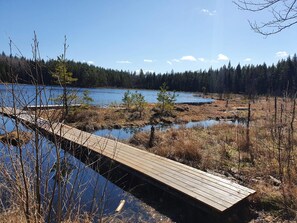 A wooden bridge over a body of water with a forested background. - 5 Star Holiday Home in Asbro (Asbro)