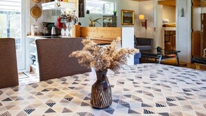 A cozy living room with a patterned tablecloth, a vase with dried flowers, and a wooden ceiling. - 8 Person Holiday Home in Hurup Thy-by Traum (Hurup Thy)