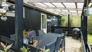 An outdoor patio with a wooden table and chairs, a grill, and a pergola structure. - 8 Person Holiday Home in Hurup Thy-by Traum (Hurup Thy)