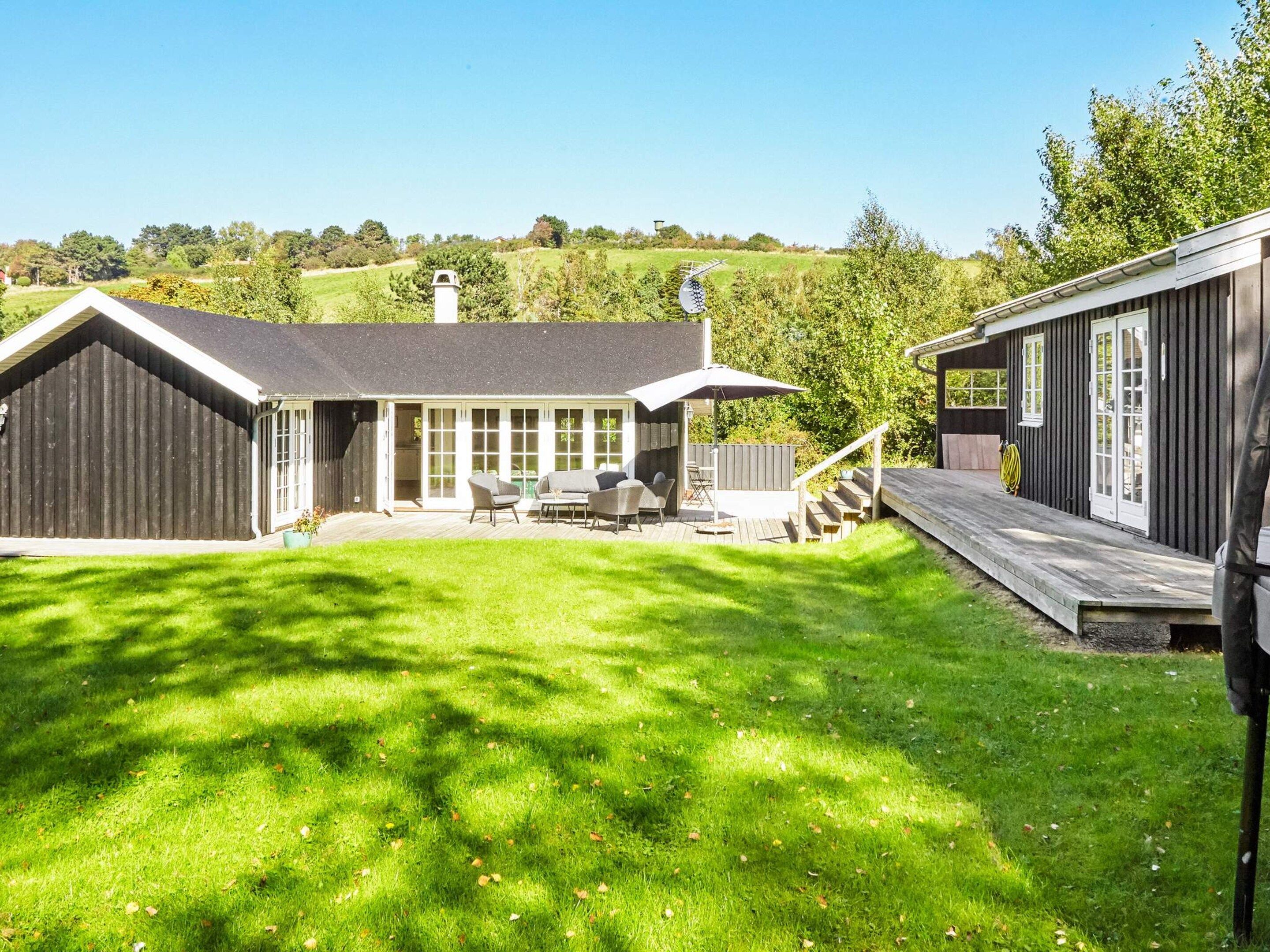 A residential property with a covered patio area, a deck, and a fenced backyard.