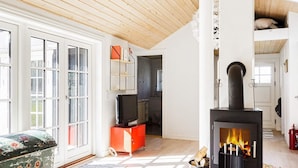 A living room with a fireplace, a television, and a sofa. - 4 Star Holiday Home in Nykobing Sj (Nykobing Sjaelland)