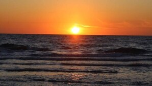A sunset over the ocean with waves. - 4 Star Holiday Home in Lokken (Lokken)