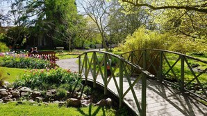 A wooden bridge over a garden path with lush greenery and flowering plants. - 6 Person Holiday Home in Visby-by Traum (Visby)