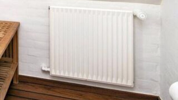 A white radiator mounted on a wall with a wooden floor. - 4 Star Holiday Home in Skagen (Skagen)