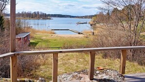 A lakeside view with a wooden deck, a dock, and a small building. - 6 Person Holiday Home in Vaxholm (Vaxholm)