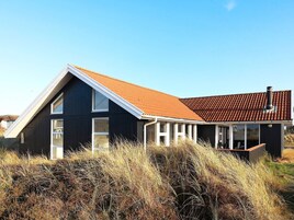 A modern house with a sloped roof and large windows.