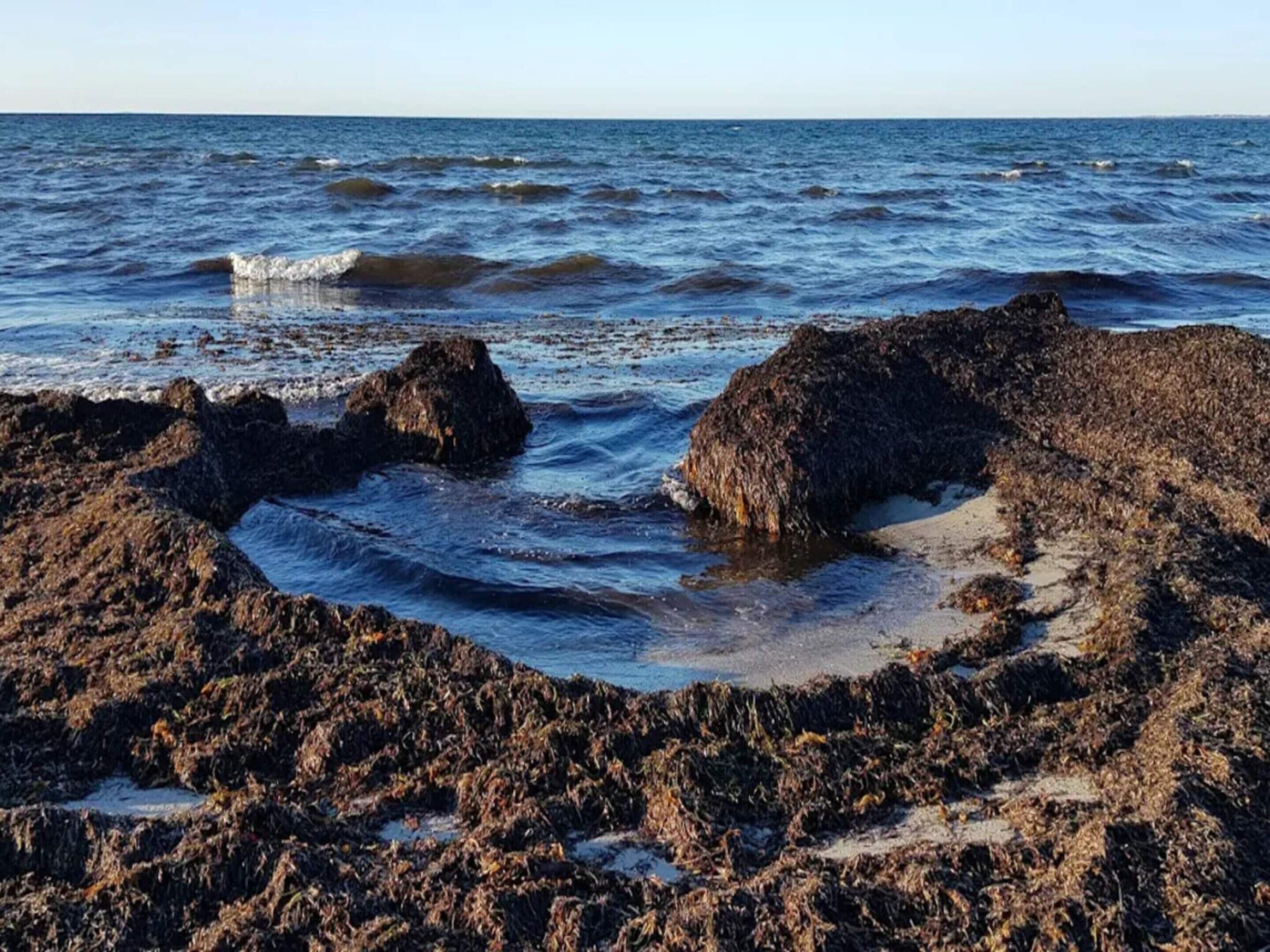 Een rotsachtige kustlijn met golven die tegen de rotsen slaan.