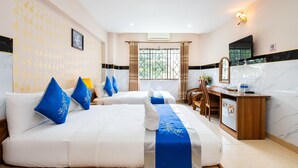 Habitació d'hotel amb dos llits, una taula de treball, una cadira i un petit frigorífic.