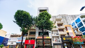 Hotel amb façana moderna, entrada ben visible i un arbre al davant.