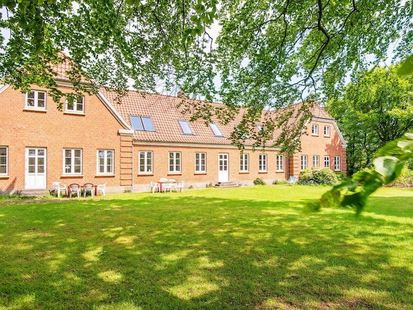 A large brick building with multiple windows and a sloped roof.