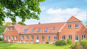 A large brick building with a sloped roof and multiple windows. - 4 Star Holiday Home in Ulfborg (Ulfborg)